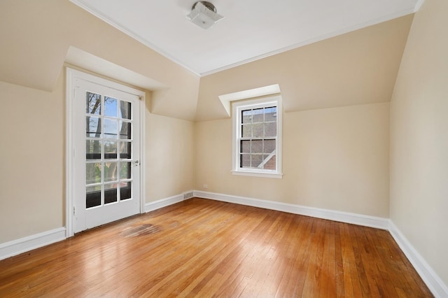 bonus room with wood-type flooring, a wealth of natural light, and baseboards