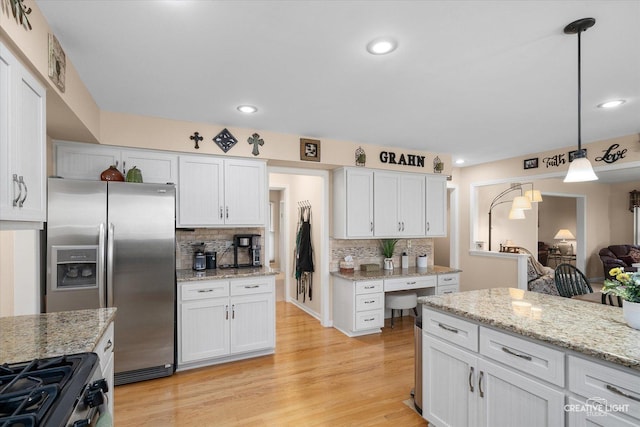 kitchen featuring tasteful backsplash, white cabinetry, light wood-style floors, and stainless steel appliances
