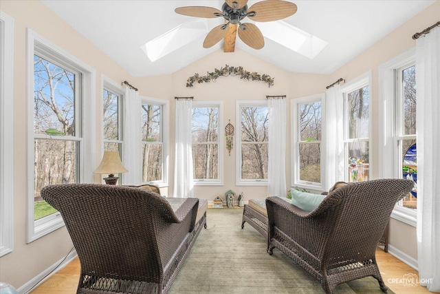 sunroom with vaulted ceiling with skylight, wood finished floors, and baseboards
