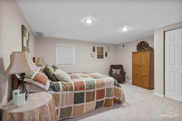 bedroom with light carpet, a closet, baseboards, and visible vents