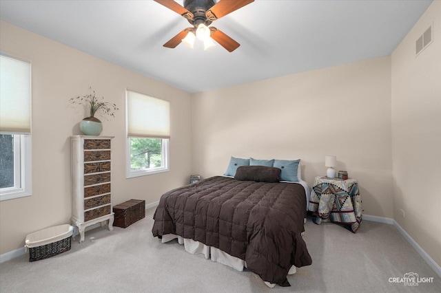 carpeted bedroom with visible vents, baseboards, and ceiling fan