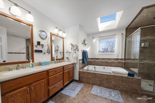 bathroom featuring a bath, a sink, double vanity, a skylight, and a stall shower