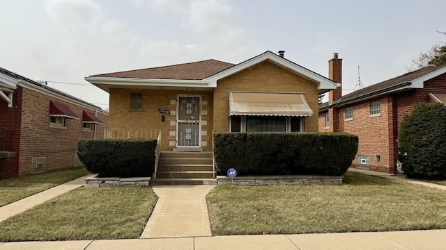 12450 S Yale Ave, Chicago, IL 60628 - bungalow-style home featuring brick siding, a chimney, and a front lawn