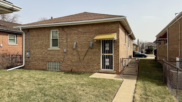 12450 S Yale Ave, Chicago, IL 60628 - back of property featuring fence, brick siding, a gate, and a lawn