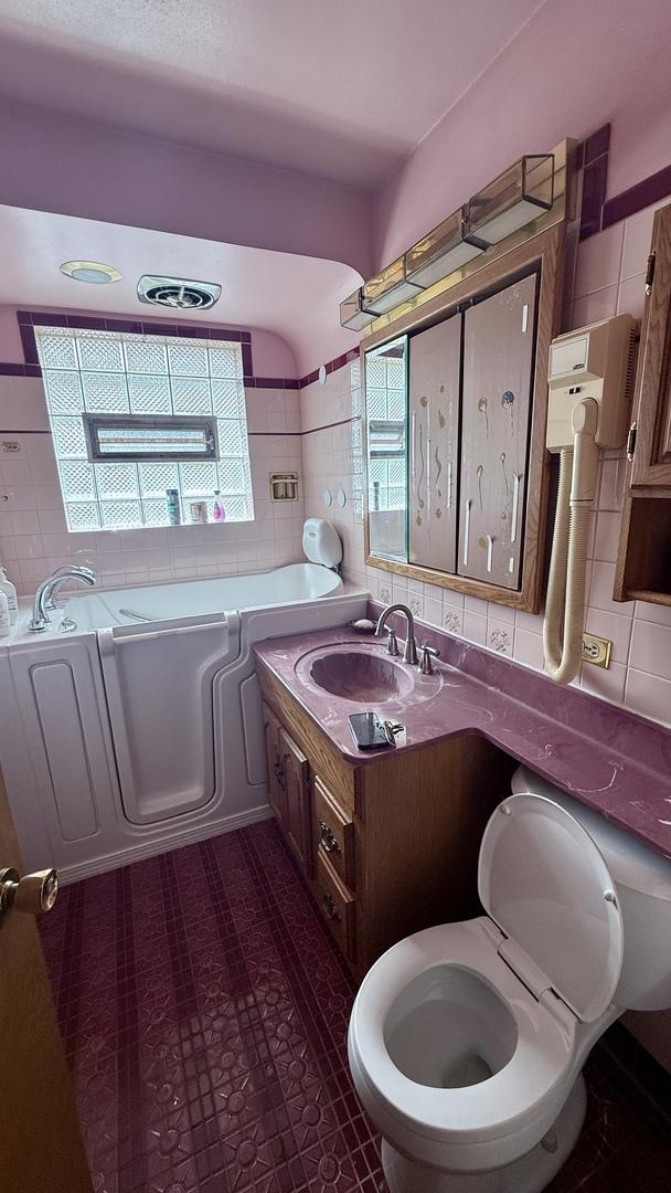 12450 S Yale Ave, Chicago, IL 60628 - full bathroom featuring a bath, plenty of natural light, and tile walls
