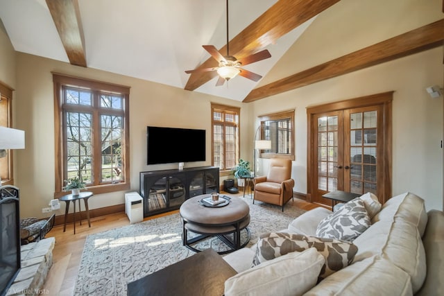 living area with vaulted ceiling with beams, french doors, ceiling fan, and light wood-style flooring