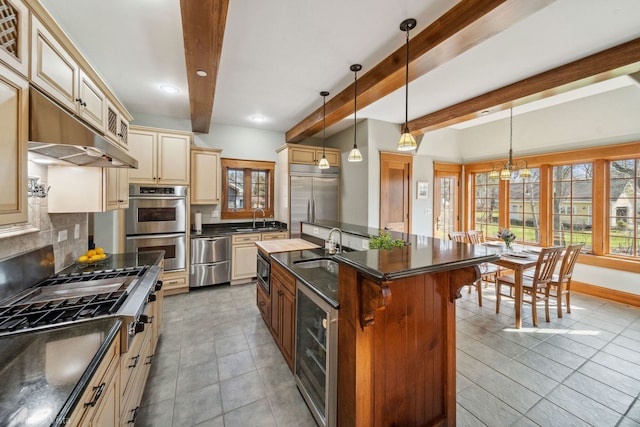 kitchen featuring wine cooler, beamed ceiling, appliances with stainless steel finishes, light tile patterned floors, and cream cabinets
