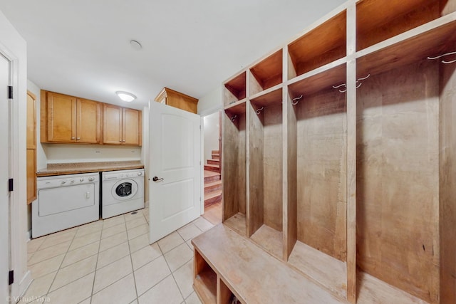 mudroom with light tile patterned floors and independent washer and dryer