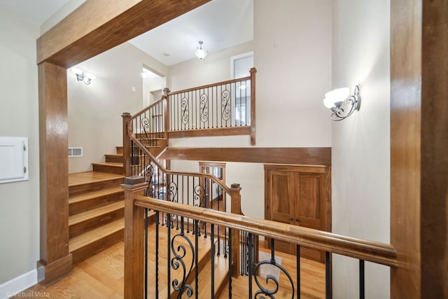 staircase featuring visible vents and wood finished floors