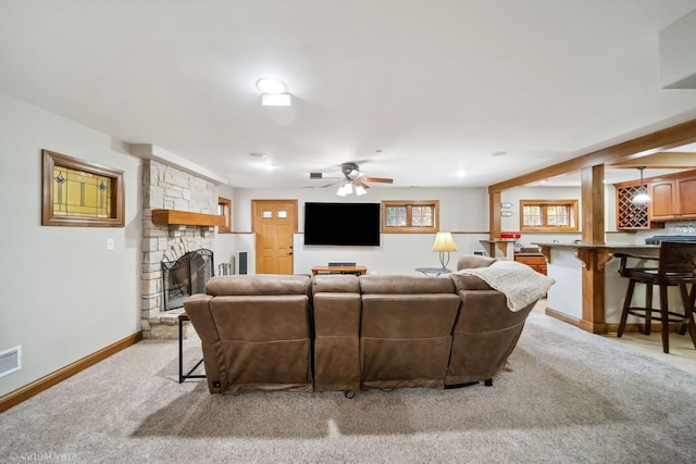 living room with light carpet, a ceiling fan, baseboards, and a fireplace