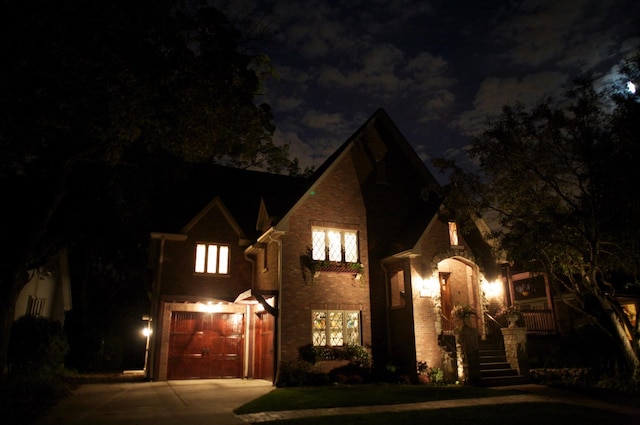 view of front of home featuring a garage, brick siding, and concrete driveway