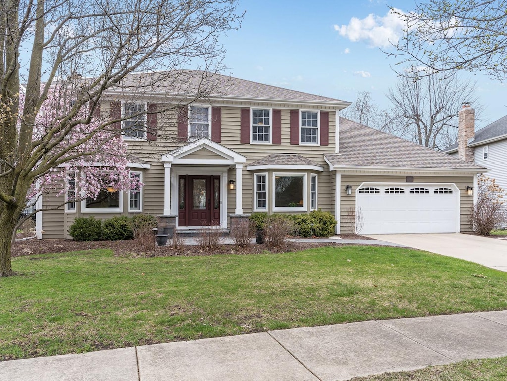 1541 Meadowland Dr, Naperville, IL 60540 - colonial home with a shingled roof, an attached garage, concrete driveway, and a front lawn