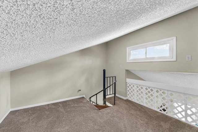 additional living space featuring carpet, a textured ceiling, and baseboards