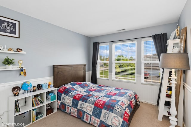 carpeted bedroom with wainscoting
