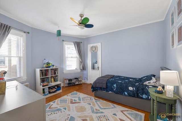 bedroom featuring ceiling fan, ornamental molding, and wood finished floors