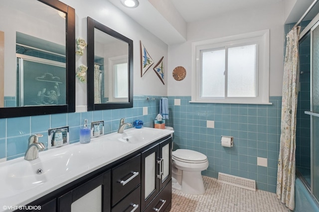 9835 Keeler Ave, Skokie, IL 60076 - bathroom featuring double vanity, tile patterned flooring, a wainscoted wall, tile walls, and shower / tub combo
