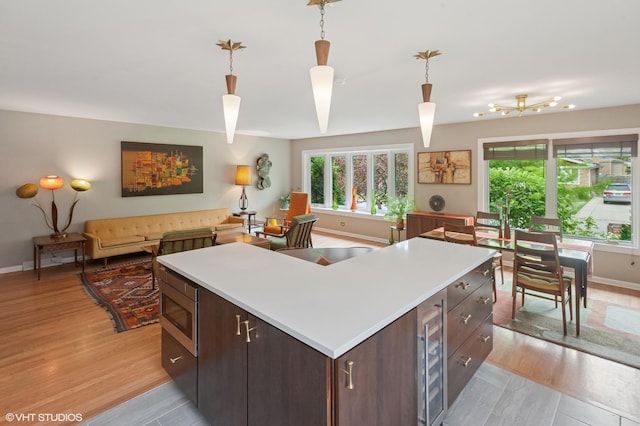 9835 Keeler Ave, Skokie, IL 60076 - kitchen with stainless steel microwave, beverage cooler, light countertops, and dark brown cabinets