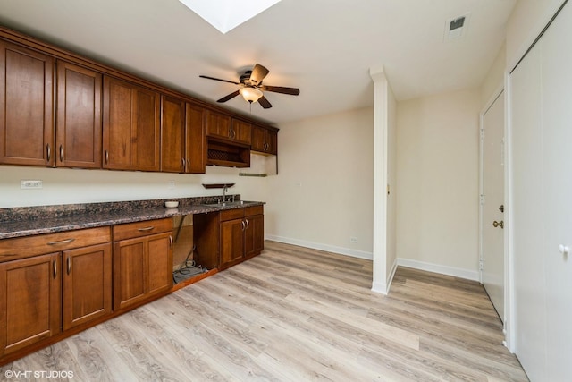 400 Mccarthy Rd Unit 421, Lemont, IL 60439 - kitchen featuring light wood finished floors, a skylight, dark stone countertops, and ceiling fan