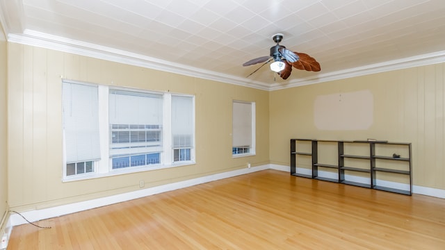 unfurnished room featuring ornamental molding, ceiling fan, wood finished floors, and baseboards