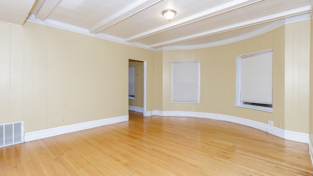 spare room with visible vents, baseboards, beam ceiling, and wood finished floors