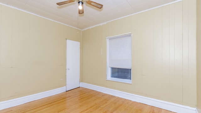 empty room with crown molding, ceiling fan, wood finished floors, and baseboards