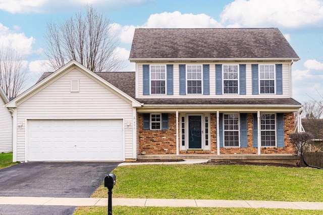 view of front of house featuring a front lawn, driveway, covered porch, a garage, and brick siding
