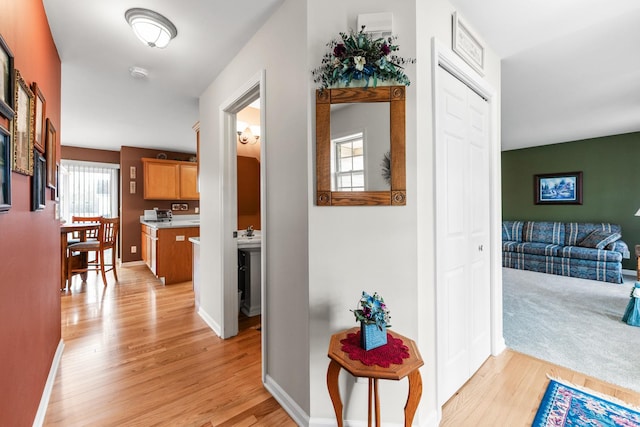 corridor with baseboards and light wood-style floors