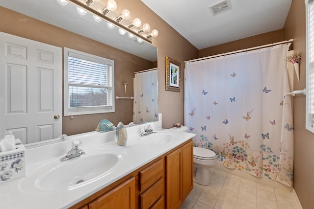 bathroom with double vanity, visible vents, toilet, and a sink