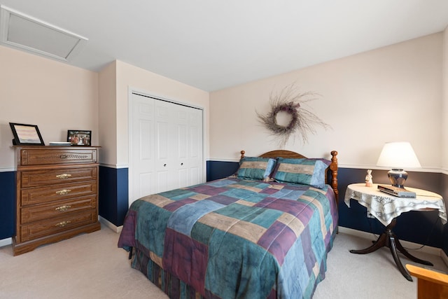 bedroom with attic access, baseboards, a closet, and light colored carpet