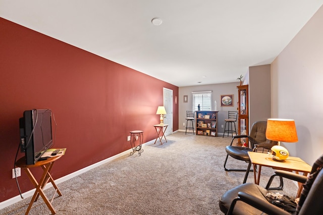 sitting room with baseboards and carpet flooring
