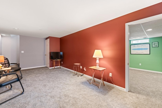 sitting room featuring baseboards and carpet