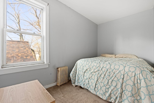 carpeted bedroom featuring multiple windows, radiator, and vaulted ceiling