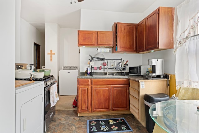 kitchen with brown cabinetry, washer / clothes dryer, black microwave, and a sink