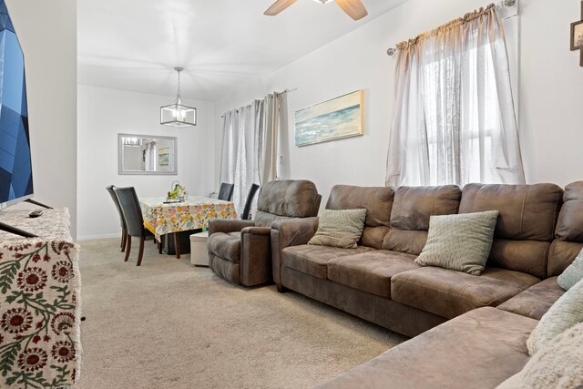 living room featuring light carpet, ceiling fan, and baseboards