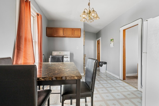 dining space with baseboards, a chandelier, and light floors