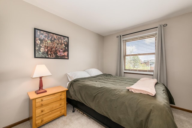 bedroom featuring baseboards and light colored carpet