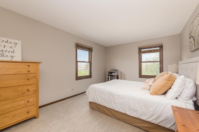 bedroom with baseboards and light colored carpet