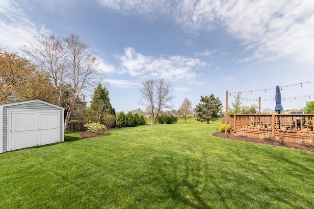 view of yard with an outdoor structure, a storage shed, and a deck