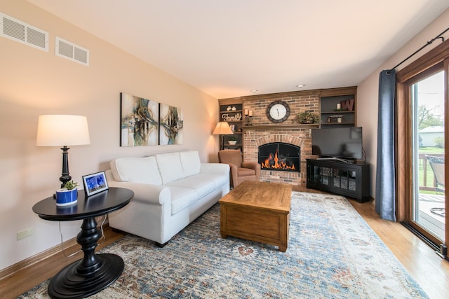 living area featuring plenty of natural light, wood finished floors, and visible vents