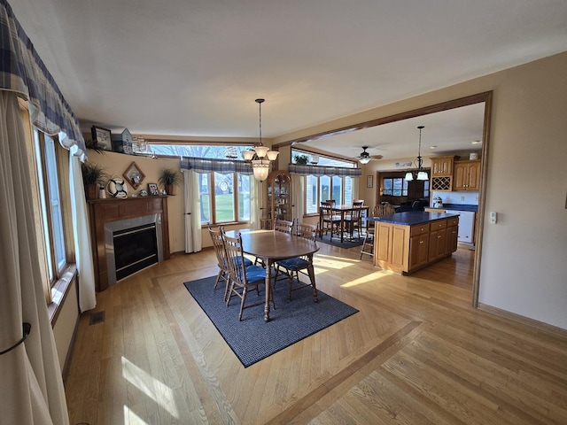 31-3 Lake Carroll Blvd, Lake Carroll, IL 61046 - dining room featuring a fireplace, ceiling fan, light wood-type flooring, and a chandelier