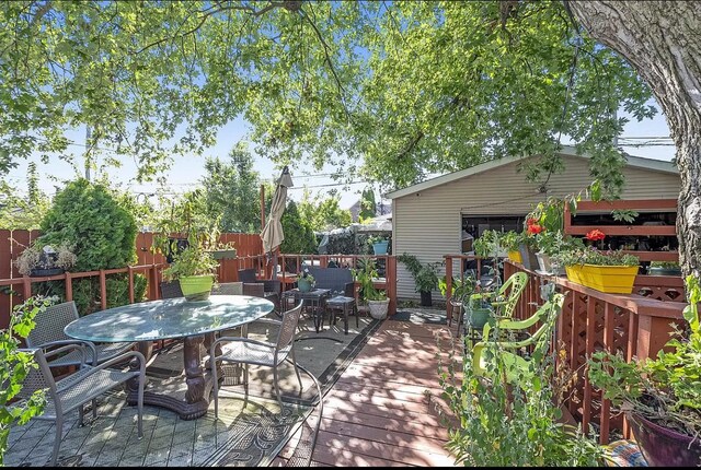 wooden terrace featuring outdoor dining space and fence