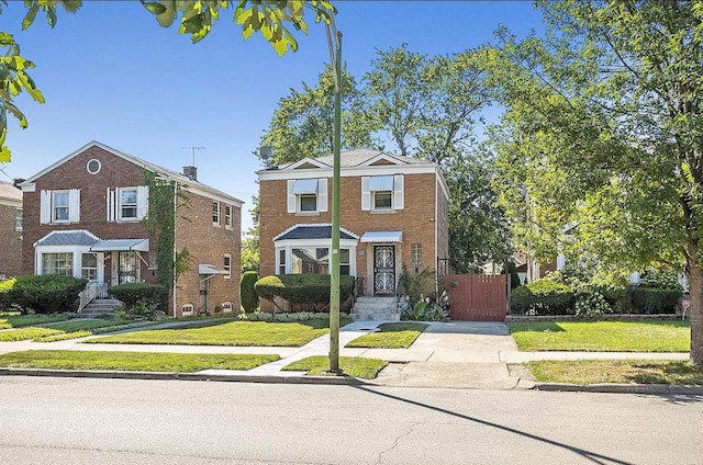 traditional-style house with a front yard, fence, and brick siding