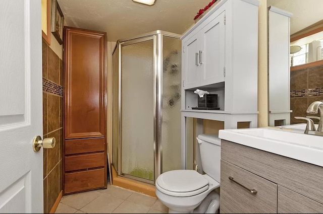 full bathroom featuring tile patterned floors, toilet, a stall shower, and vanity