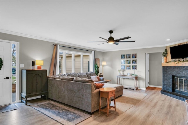 415 E 14th St, Gibson City, IL 60936 - living area featuring a fireplace, light wood-style floors, crown molding, and ceiling fan