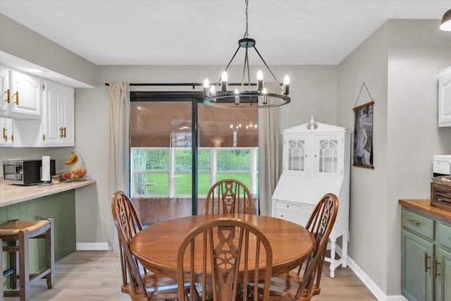 415 E 14th St, Gibson City, IL 60936 - dining room featuring light wood finished floors, baseboards, and a notable chandelier