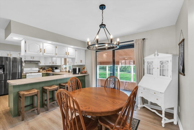 415 E 14th St, Gibson City, IL 60936 - dining space featuring a chandelier, light wood-style floors, and baseboards