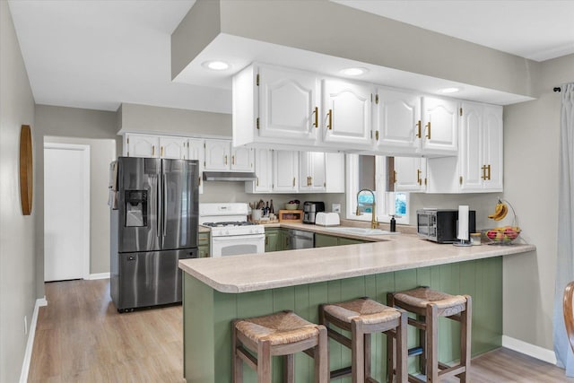 415 E 14th St, Gibson City, IL 60936 - kitchen featuring white cabinets, a peninsula, under cabinet range hood, and stainless steel appliances