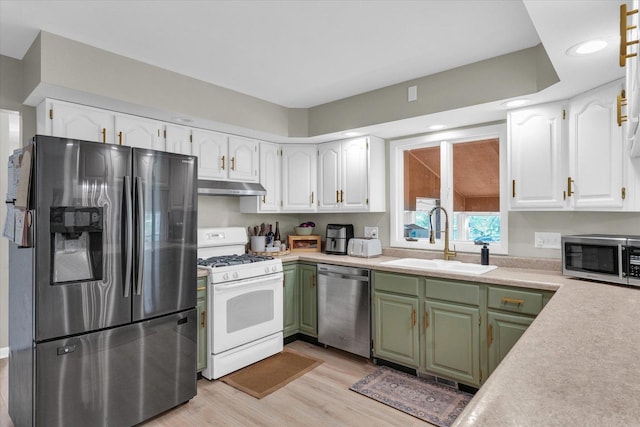 415 E 14th St, Gibson City, IL 60936 - kitchen featuring green cabinetry, under cabinet range hood, stainless steel appliances, a sink, and white cabinetry