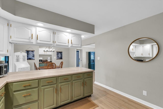 415 E 14th St, Gibson City, IL 60936 - kitchen featuring light wood-type flooring, light countertops, white cabinets, and green cabinetry