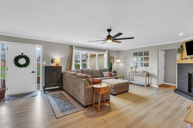 415 E 14th St, Gibson City, IL 60936 - living room featuring light wood finished floors, a ceiling fan, a brick fireplace, and crown molding